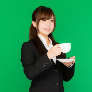 立ったままコーヒーを飲む女性